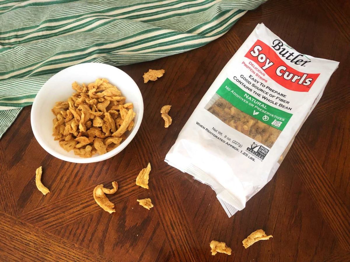 Package of soy curls and soy curls in a white bowl on a table
